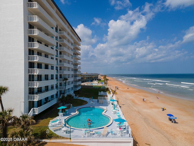 view of pool featuring a view of the beach, a patio area, and a water view