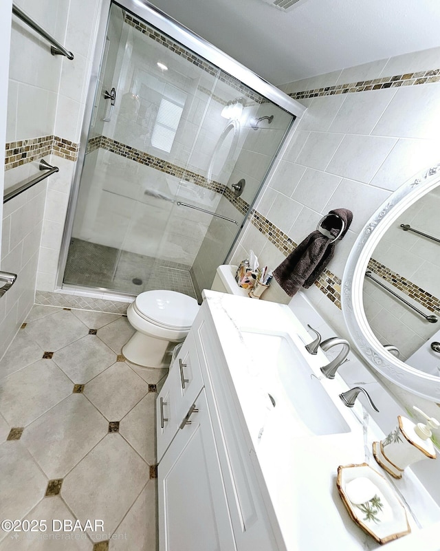 bathroom featuring vanity, tile patterned flooring, toilet, and walk in shower