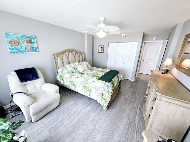 bedroom with hardwood / wood-style floors, ceiling fan, and a closet