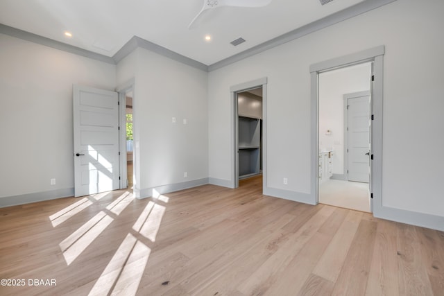 spare room featuring light wood-style floors, visible vents, baseboards, and a ceiling fan