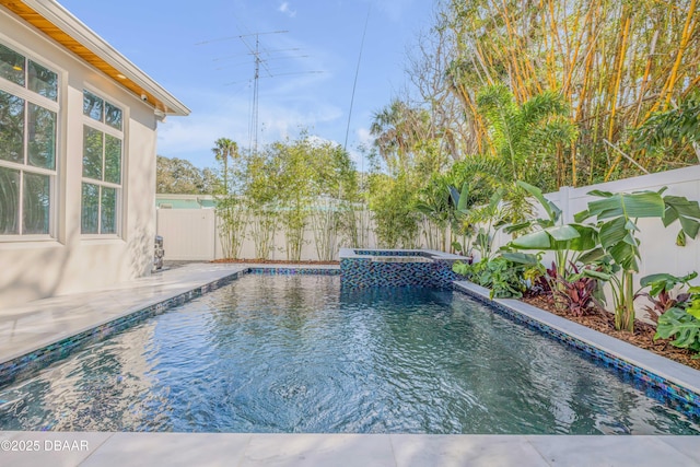 view of swimming pool with a patio area, a fenced backyard, and a pool with connected hot tub