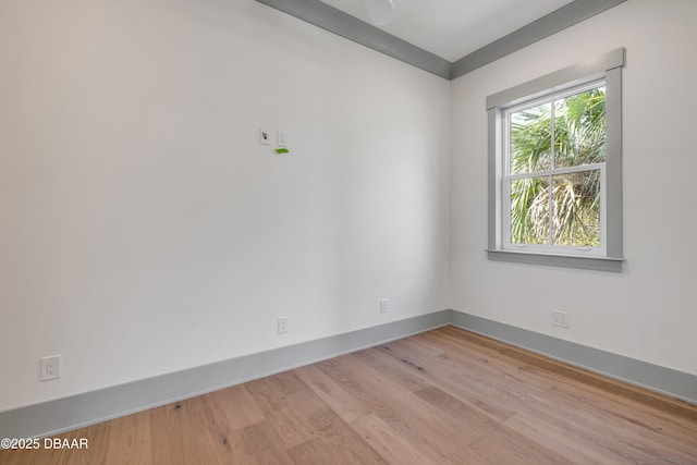 unfurnished room with light wood-type flooring and baseboards