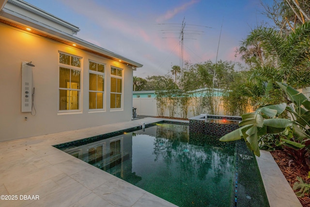 pool at dusk with a fenced in pool, fence, and a patio