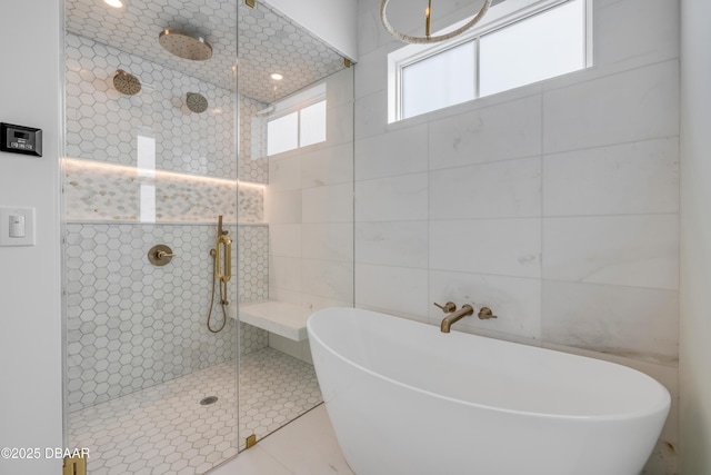 full bathroom featuring a freestanding tub, tile walls, and a walk in shower