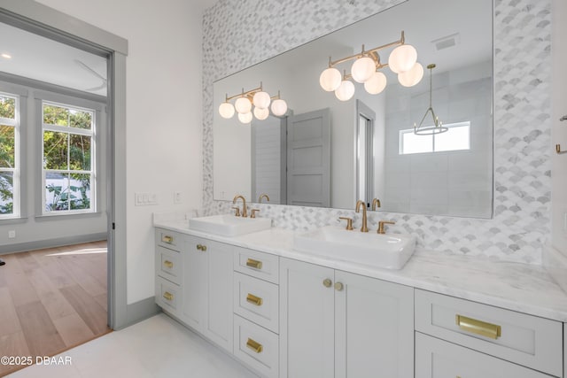 full bathroom featuring wood finished floors, visible vents, a sink, and double vanity