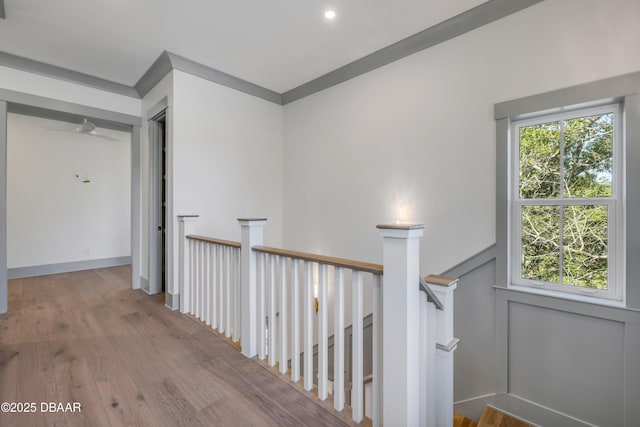 corridor featuring an upstairs landing and wood finished floors