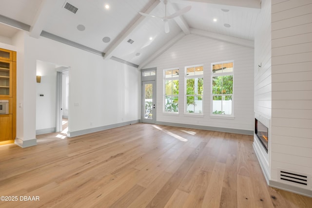 unfurnished living room with visible vents, light wood-style flooring, a ceiling fan, a large fireplace, and beamed ceiling