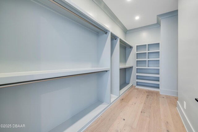 walk in closet with light wood-style floors