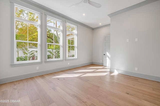 spare room featuring recessed lighting, a ceiling fan, baseboards, light wood-type flooring, and crown molding