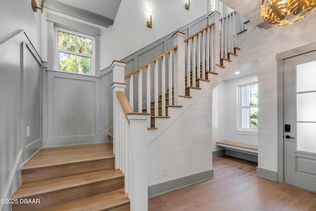 stairway with a notable chandelier and wood finished floors