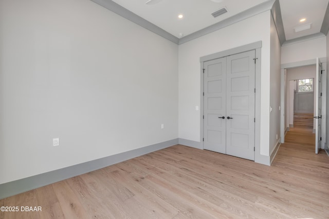 unfurnished bedroom featuring a closet, baseboards, visible vents, and light wood finished floors