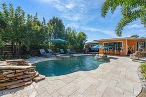 view of swimming pool with a patio area and an in ground hot tub