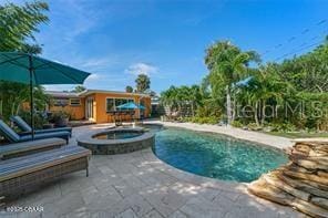 view of swimming pool with a pool with connected hot tub and a patio area