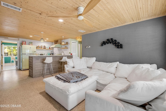 living room featuring light speckled floor, wooden ceiling, recessed lighting, visible vents, and a dry bar