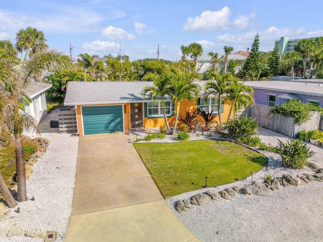 view of front of home featuring a garage, concrete driveway, a front lawn, and fence