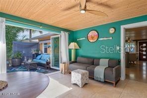 living room featuring ceiling fan and wood ceiling