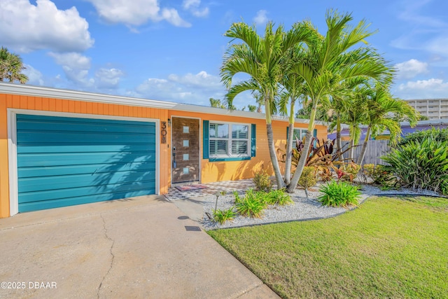 view of front of home with a garage, concrete driveway, and a front yard