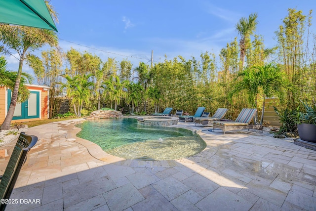 view of swimming pool featuring a pool with connected hot tub and a patio area