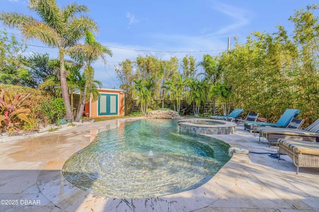 view of pool featuring a pool with connected hot tub, a patio, and an outdoor structure