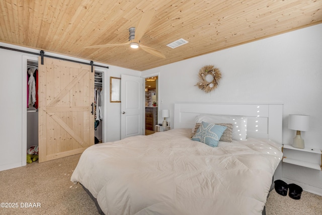 bedroom featuring wood ceiling, a barn door, visible vents, and a ceiling fan