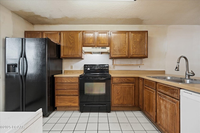 3548 Forest Branch Dr Unit C, Port Orange, FL 32129 - kitchen featuring black appliances, under cabinet range hood, brown cabinetry, light countertops, and a textured ceiling