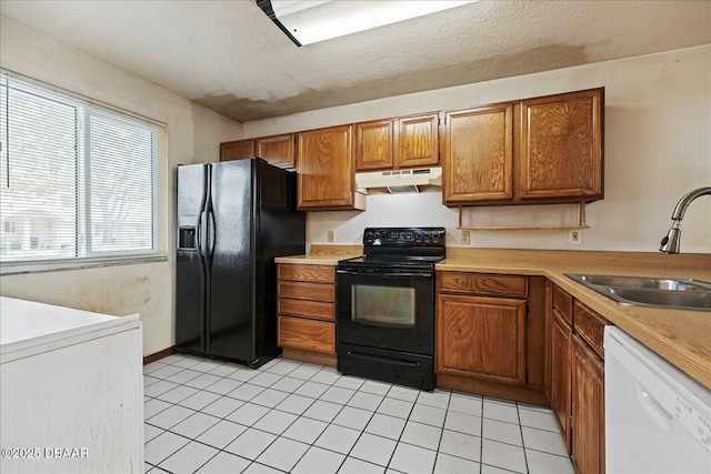 3548 Forest Branch Dr Unit C, Port Orange, FL 32129 - kitchen with black appliances, under cabinet range hood, brown cabinetry, light countertops, and a textured ceiling