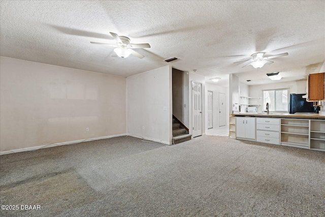 3548 Forest Branch Dr Unit C, Port Orange, FL 32129 - unfurnished living room featuring ceiling fan, a textured ceiling, stairway, and carpet