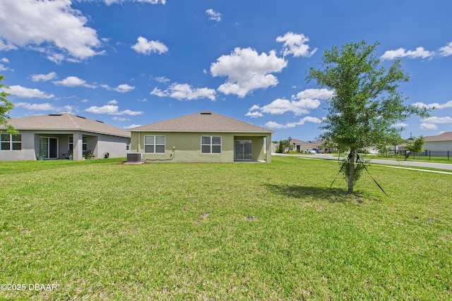 2625 Neverland Dr, New Smyrna Beach, FL 32168 - rear view of property with central air condition unit, a yard, and stucco siding