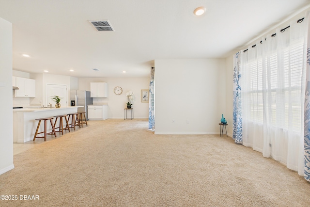 2625 Neverland Dr, New Smyrna Beach, FL 32168 - living area with light carpet, baseboards, visible vents, and recessed lighting