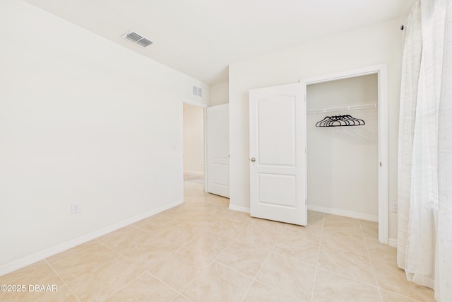 2625 Neverland Dr, New Smyrna Beach, FL 32168 - unfurnished bedroom with visible vents, baseboards, a closet, and light tile patterned flooring