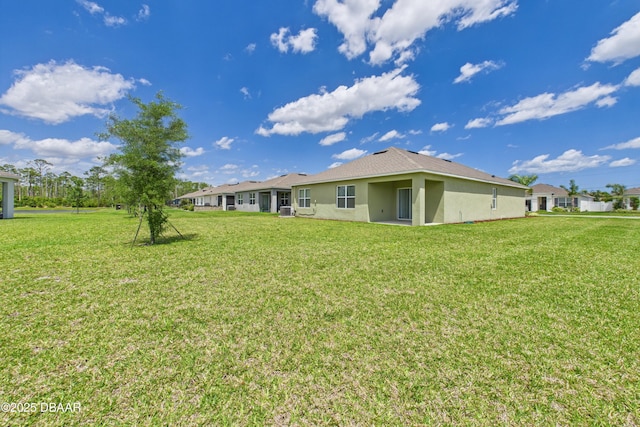2625 Neverland Dr, New Smyrna Beach, FL 32168 - back of house with a yard and stucco siding