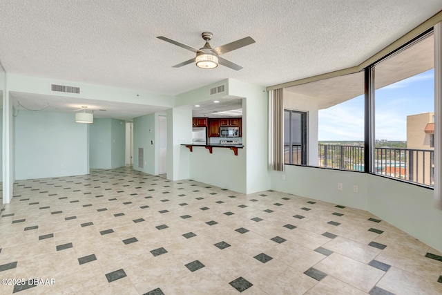 2425 S Atlantic Ave Unit 801, Daytona Beach Shores, FL 32118 - unfurnished living room with a ceiling fan, a textured ceiling, and light tile patterned flooring