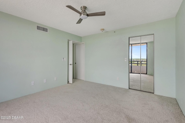 2425 S Atlantic Ave Unit 801, Daytona Beach Shores, FL 32118 - unfurnished bedroom with carpet floors, access to outside, a textured ceiling, and a ceiling fan