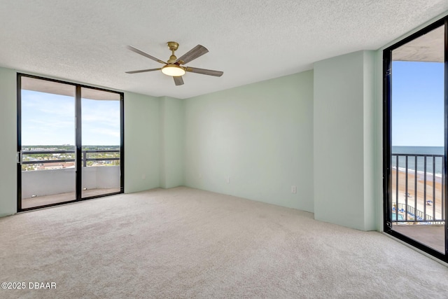 2425 S Atlantic Ave Unit 801, Daytona Beach Shores, FL 32118 - carpeted spare room with floor to ceiling windows, a ceiling fan, and a textured ceiling