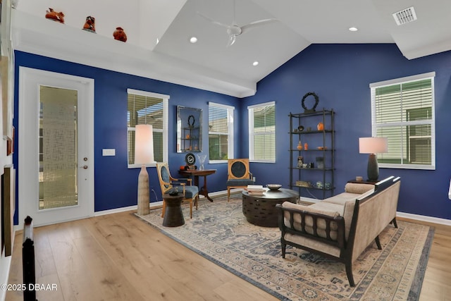 sitting room featuring lofted ceiling, visible vents, baseboards, and wood finished floors