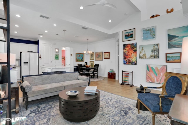 living room with a chandelier, ornamental molding, wood finished floors, and recessed lighting