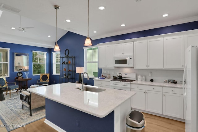 kitchen featuring visible vents, light wood-style floors, white cabinetry, a sink, and white appliances