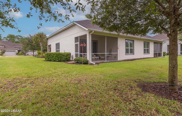 back of house with a sunroom, a yard, and a garage