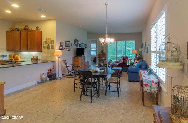 dining space featuring light tile patterned flooring and an inviting chandelier