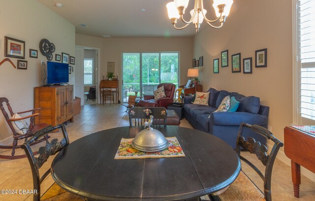 living room with light tile patterned floors and an inviting chandelier