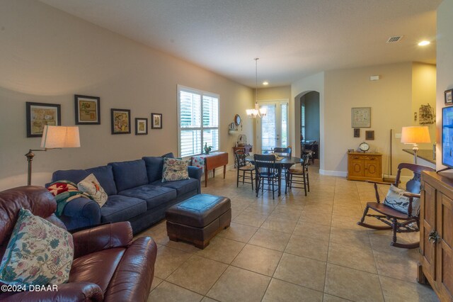 living room with a notable chandelier and light tile patterned floors