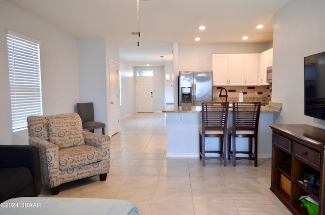 living room featuring sink and light tile patterned floors