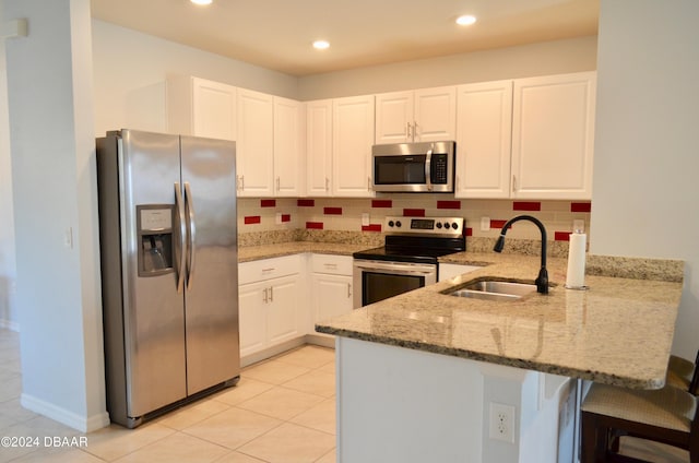 226 Meghan Cir, Deland, FL 32724 - kitchen with appliances with stainless steel finishes, a sink, a peninsula, light stone countertops, and white cabinets
