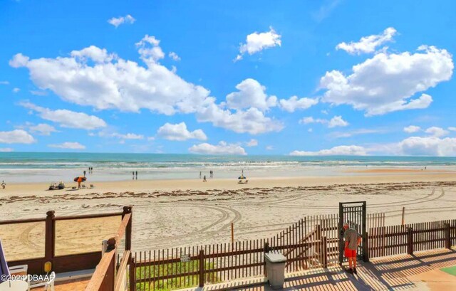 property view of water with a view of the beach and fence