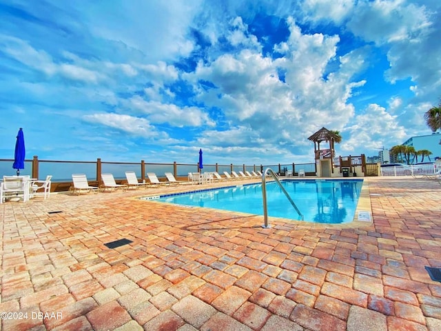pool featuring fence and a patio area