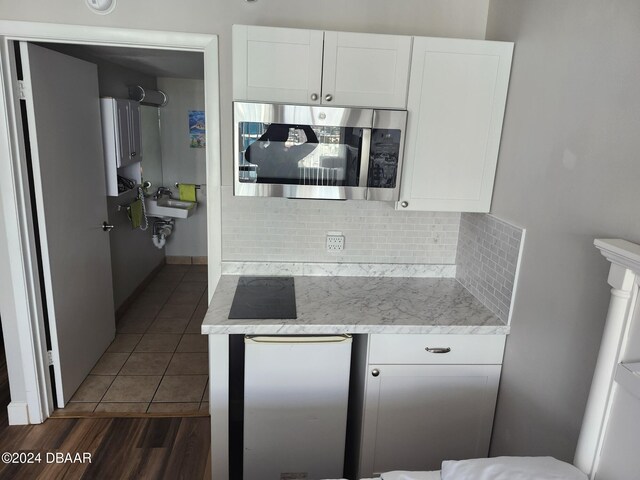 kitchen featuring white cabinets, decorative backsplash, and dark hardwood / wood-style floors