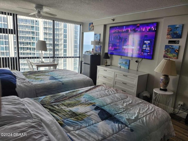 bedroom with multiple windows, a textured ceiling, ceiling fan, and wood-type flooring