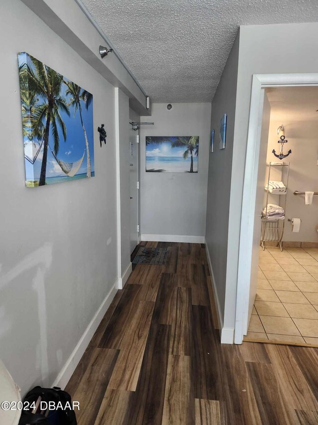 corridor featuring hardwood / wood-style floors and a textured ceiling