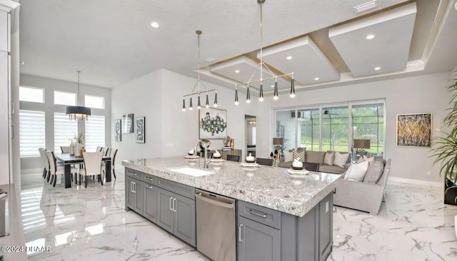 kitchen featuring sink, hanging light fixtures, gray cabinets, dishwasher, and an island with sink