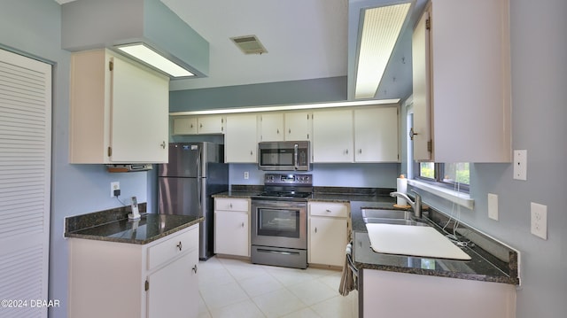 kitchen featuring dark stone countertops, white cabinetry, sink, and stainless steel appliances